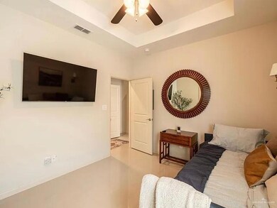 Living room featuring ceiling fan and a raised ceiling