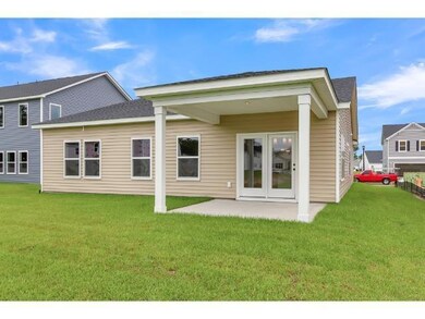Rear view of property with a lawn and a patio area