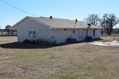 Back of house with central AC and a yard