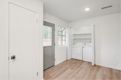 Washroom featuring light wood-style floors and washing machine and dryer