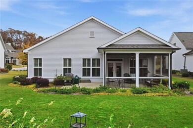 Back of property with a sunroom, a yard, a shingled roof, and french doors