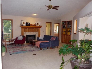 The living room includes a gas log fireplace, vaulted ceiling and built-in shelving/cabinets.