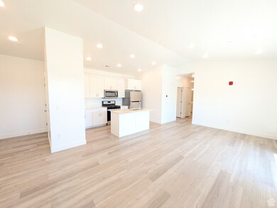 Living room with recessed lighting, light wood-style floors, and vaulted ceiling