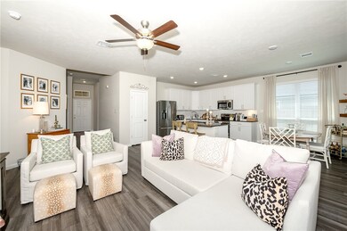 Living area with dark wood-style floors, ceiling f
