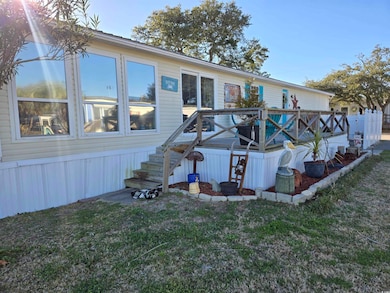 Rear view of property with a deck and a lawn