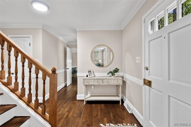 Entrance foyer featuring crown molding and dark ha