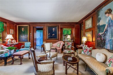 Paneled sitting room with a view of the entryway w