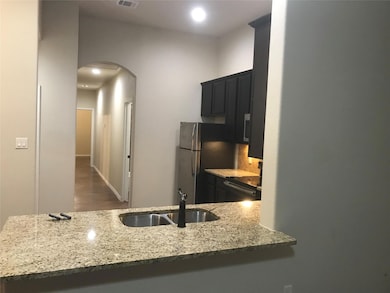 Kitchen featuring a sink, arched walkways, light 