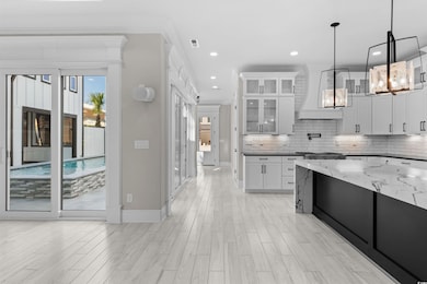 Kitchen featuring white cabinets, a chandelier, cu