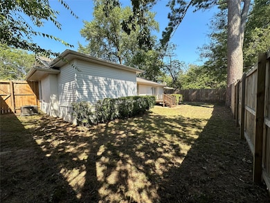 View of property exterior featuring a lawn, a fenc