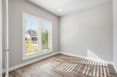 Empty room with wood finished floors and recessed lighting