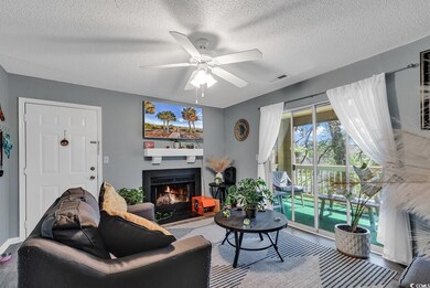 Living room with a textured ceiling, a lit firepla