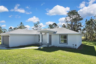 View of front facade with a front yard, a garage, stucco siding, and roof with shingles