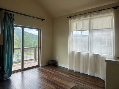 Empty room with lofted ceiling and dark wood-type