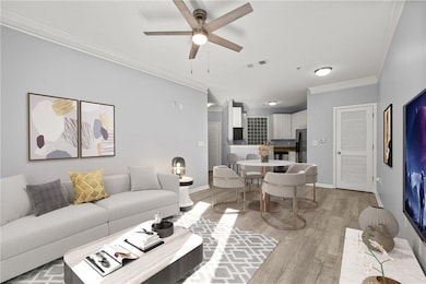Living room with crown molding, light wood finished floors, and ceiling fan