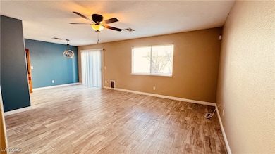 Empty room featuring ceiling fan and light wood-st