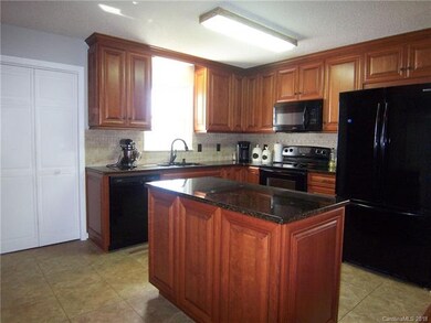 Kitchen has an island, granite counter tops, and t
