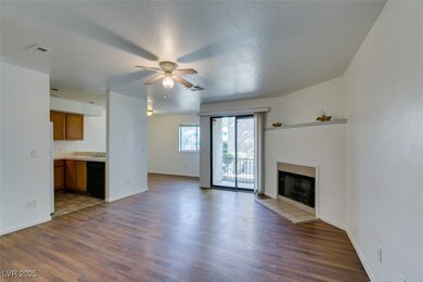 Unfurnished living room featuring dark wood-style floors, a fireplace with flush hearth, ceiling fan, and a textured ceiling