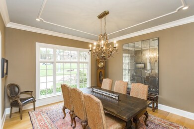 The formal dining room has a gorgeous chandelier accented by detailed ceiling trim. 