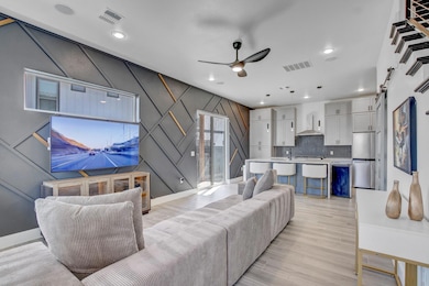 Living area with a ceiling fan, light wood-type f
