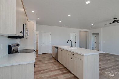 Kitchen with light brown cabinets, light countertops, recessed lighting, light wood finished floors, and appliances with stainless steel finishes