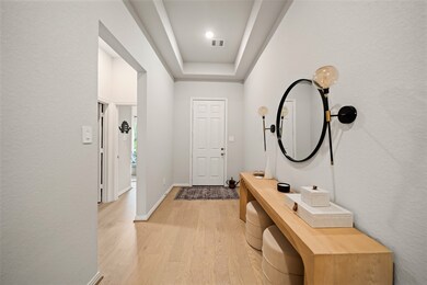 The foyer features elegant light wood flooring and