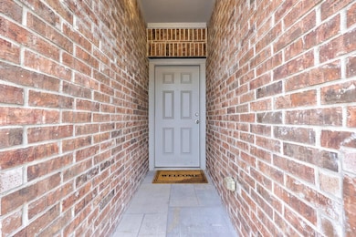 Entrance to property featuring brick siding