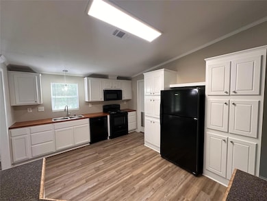Kitchen with light wood-style floors, white cabine