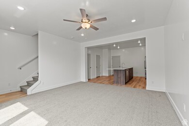 Unfurnished living room with recessed lighting, light colored carpet, stairs, ceiling fan, and light wood-style floors