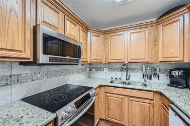 Kitchen featuring sink, light stone counters, back