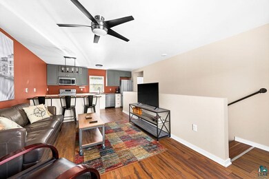 Living room featuring ceiling fan and dark hardwoo
