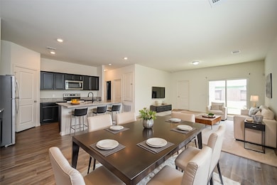 In this virtually staged view, bright open space welcomes formal dining pieces.