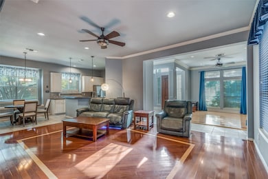Living room with ceiling fan, healthy amount of natural light, crown molding, light wood finished floors, and recessed lighting