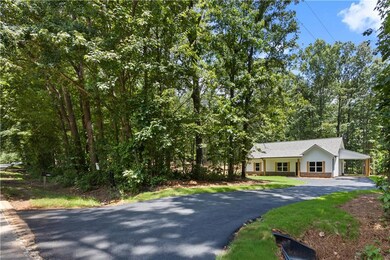 View of front of home featuring driveway and an attached carport