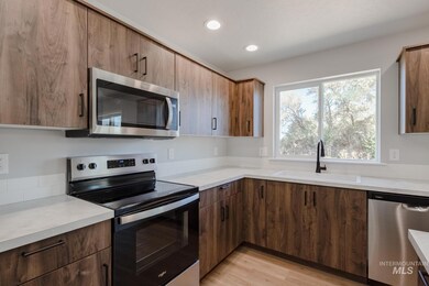 Kitchen with stainless steel appliances, light wood-style floors, light countertops, recessed lighting, and modern cabinets