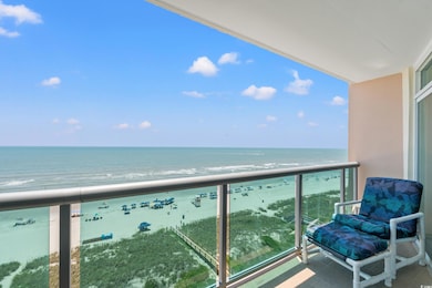 Balcony featuring view of water and beach
