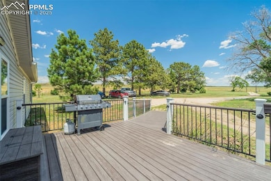 Wooden terrace with area for grilling, a lawn, and a view of rural / pastoral area