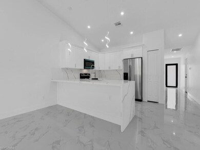 Kitchen with stainless steel fridge with ice dispenser, a peninsula, white cabinetry, light marble finish floors, and recessed lighting