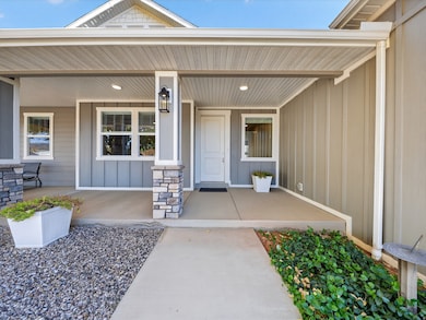 Property entrance featuring board and batten siding and covered porch