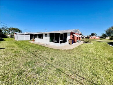 Back of house featuring a yard and a screened lana