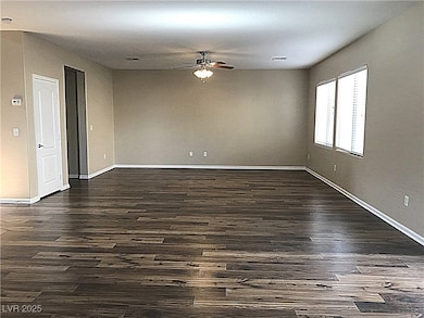 Unfurnished room with dark wood-type flooring and ceiling fan