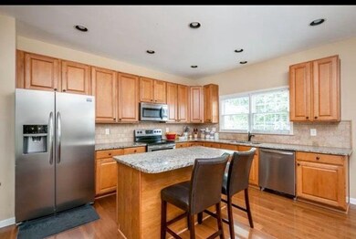 Kitchen featuring stainless steel appliances, light wood-type flooring, decorative backsplash, a kitchen island, and recessed lighting