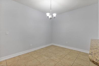 Unfurnished room with baseboards and a chandelier