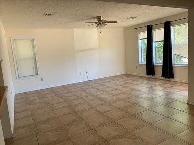 Spare room featuring ceiling fan, a textured ceili