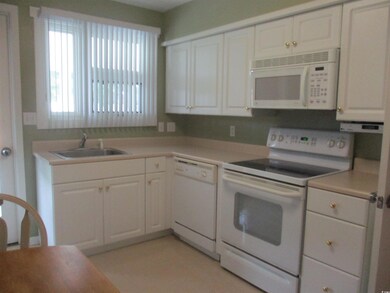 Kitchen featuring white cabinets, sink, and white appliances