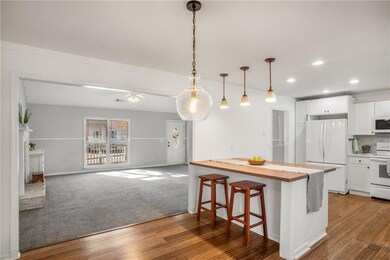 Kitchen featuring a kitchen bar, white appliances,