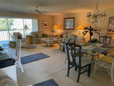 Dining space with light carpet, a textured ceiling, a chandelier, and a ceiling fan