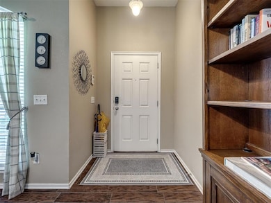 Foyer entrance with dark wood-style flooring and baseboards