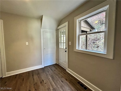 Doorway featuring baseboards and wood finished floors