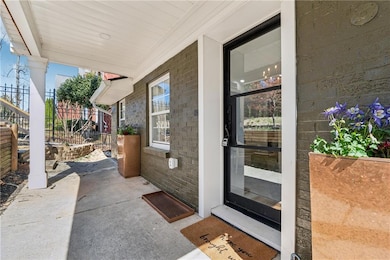 Doorway to property with brick siding and fence